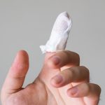 Mature man presses hands to heart has cardio problems suffers heart attack and chest pain stands with closed eyes needs doctors help wears casual jumper isolated over brown wall. Health problems